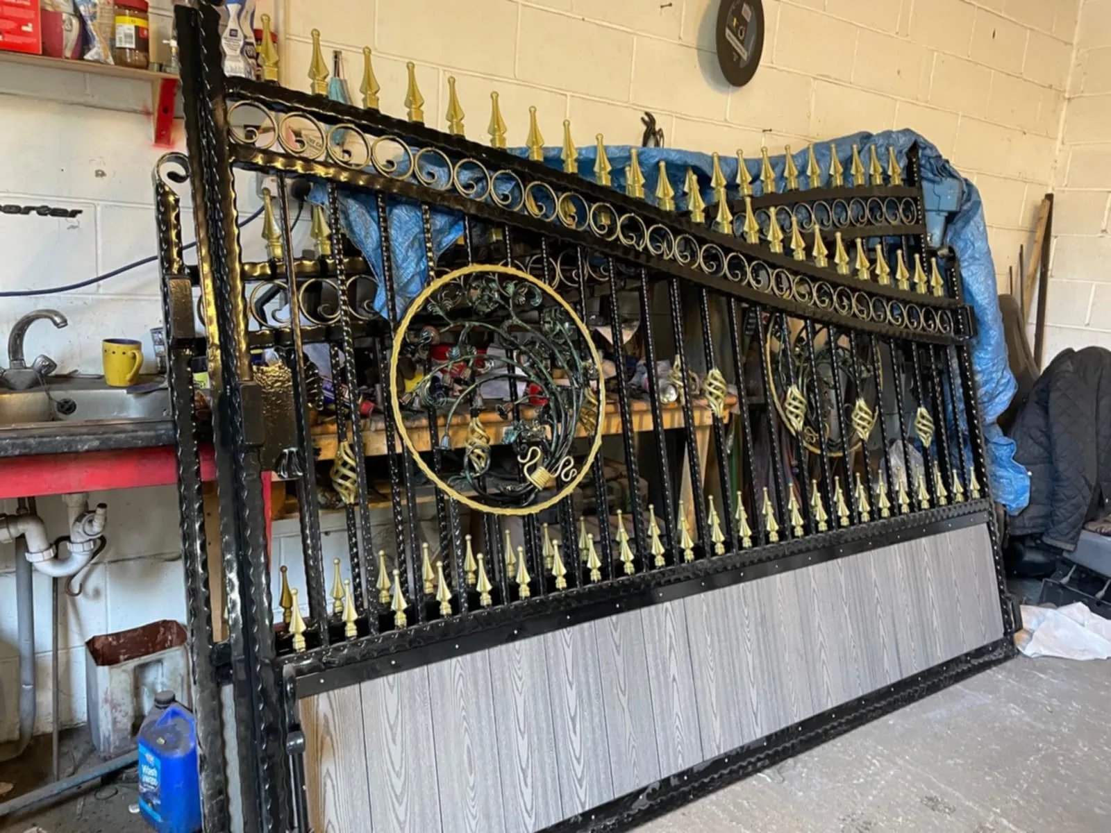Decorative metal gates leaning against a workshop wall